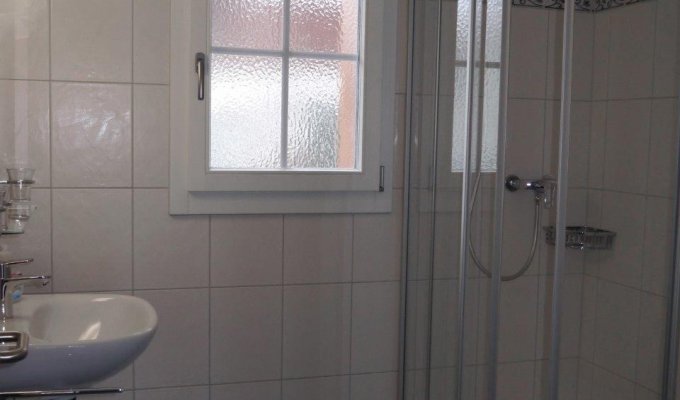 A bathroom with shower, sink, toilet and washing machine + dryer